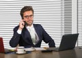 Lifestyle corporate company portrait of young happy and busy business man working at modern office talking on mobile phone by wind Royalty Free Stock Photo