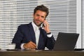 Lifestyle corporate company portrait of young happy and successful business man working relaxed at modern office sitting by window