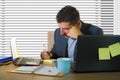 Lifestyle corporate portrait of young attractive busy and confident businessman working at office computer desk writing notes