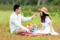 Lifestyle couple picnic and relax. People young woman and man having fun and happy playing guitar picnic in the meadow and field s Royalty Free Stock Photo