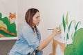 Lifestyle creative hobby and freelance artistic work side job concept. Caucasian woman artist hand painting murals on walls Royalty Free Stock Photo