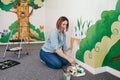 Lifestyle creative hobby and freelance artistic work side job concept. Caucasian woman artist hand painting murals on walls Royalty Free Stock Photo