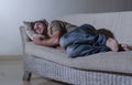 Lifestyle dramatic light portrait of young sad and depressed man lying at shady home couch in pain and depression feeling lost loo Royalty Free Stock Photo