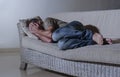 Lifestyle dramatic light portrait of young sad and depressed man lying at shady home couch in pain and depression feeling lost loo Royalty Free Stock Photo