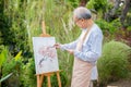 Lifestyle elderly people smile paint at his easel outside home