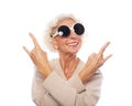 Senior woman wearing big sunglasses doing funky action isolated on white background