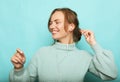 Lifestyle, emotion and people concept: beautiful young woman in a blue sweater smiles and dances, feels happy