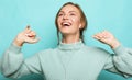 Lifestyle, emotion and people concept: beautiful young woman in a blue sweater smiles and dances, feels happy