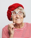 lifestyle, emotion and people concept: funny grandmother with fake glasses, laughs and ready for party