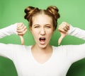 Lifestyle, emotion and people concept: Thumb down sign, young woman with unhappy negative expression Royalty Free Stock Photo