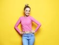 Lifestyle, emotion and people concept: Young smiling blond woman over yellow background