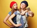 Two young hipster girls friends  taking selfie over yellow background Royalty Free Stock Photo