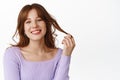 Lifestyle and fashion concept. Beautiful and stylish woman touch her hair, new hairstyle with bangs, looking happy and