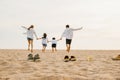 lifestyle father, mother and kids take off shoes running on sand Royalty Free Stock Photo