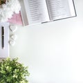 Flat lay with different accessories; flower bouquet, pink roses, open book, Bible