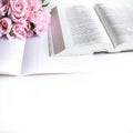 Flat lay with different accessories; flower bouquet, pink roses, open book, Bible Royalty Free Stock Photo