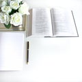 Flat lay with different accessories; flower bouquet, pink roses, open book, Bible