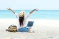 Lifestyle freelance woman raise arms relax after using laptop working on the beach. Royalty Free Stock Photo