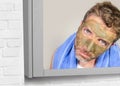 Lifestyle funny portrait of young attractive and surprised man horrified looking himself on bathroom mirror ugly and weird face ap Royalty Free Stock Photo