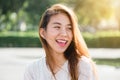 Lifestyle happy young adult asian woman smiling with teeth smile outdoors and walking on city street at sunset time. Royalty Free Stock Photo