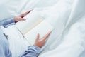 Lifestyle happy young Asian woman enjoying lying on the bed reading book pleasure in casual clothing at home. Royalty Free Stock Photo