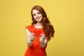 Lifestyle and Holiday Concept - Portrait Young happy red hair woman in orange beautiful dress holding big red heart Royalty Free Stock Photo