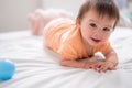 lifestyle home portrait of happy and beautiful 8 months old baby girl mixed race Asian Caucasian playing with ball cheerful on bed