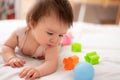 lifestyle home portrait of sweet and adorable mixed ethnicity Asian Caucasian baby girl playing with color blocks on bed excited Royalty Free Stock Photo