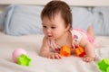 lifestyle home portrait of sweet and adorable mixed ethnicity Asian Caucasian baby girl playing with color blocks on bed excited Royalty Free Stock Photo