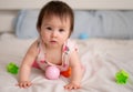 lifestyle home portrait of sweet and adorable mixed ethnicity Asian Caucasian baby girl playing with color blocks on bed excited Royalty Free Stock Photo