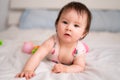 lifestyle home portrait of sweet and adorable mixed ethnicity Asian Caucasian baby girl playing with color blocks on bed excited Royalty Free Stock Photo