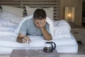 Lifestyle home portrait of young exhausted and wasted man waking up suffering headache and hangover after drinking alcohol at nigh Royalty Free Stock Photo