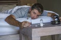 Lifestyle home portrait of young exhausted and wasted man waking up suffering headache and hangover after drinking alcohol at nigh Royalty Free Stock Photo