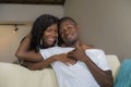 Lifestyle home portrait of young happy and successful romantic African American couple in love relaxed sitting comfortable Royalty Free Stock Photo