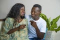 Lifestyle home portrait of young romantic and happy black African American couple in love drinking wine cup at living room couch Royalty Free Stock Photo