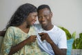 Lifestyle home portrait of young romantic and happy black African American couple in love drinking wine cup at living room couch Royalty Free Stock Photo