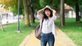 Lifestyle Image of carefree traveling smiling woman in white shirt and hat spending her leisure time on the park. Summer mood Royalty Free Stock Photo