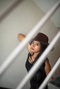 Lifestyle images of young Indian sexy girl in black western dress and cowboy hat on the landing of a staircase with railings