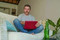 Lifestyle indoors portrait of young attractive and handsome happy man sitting at home sofa couch working online with laptop comput Royalty Free Stock Photo