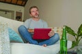 Lifestyle indoors portrait of young attractive and handsome happy man sitting at home sofa couch working online with laptop comput Royalty Free Stock Photo