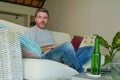 Lifestyle indoors portrait of young attractive and handsome happy man sitting at home sofa couch working online with laptop comput Royalty Free Stock Photo