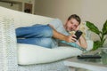 Lifestyle indoors portrait of young handsome and attractive happy man using internet dating online app on mobile phone or networki Royalty Free Stock Photo