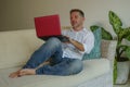 Lifestyle indoors portrait of young happy and attractive business man working with laptop computer from home comfortable at living Royalty Free Stock Photo