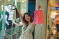 Lifestyle indoors portrait of young happy and beautiful Asian Korean woman carrying shopping bags in mall buying cheerful walking