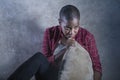 lifestyle indoors portrait of young sad and depressed black african American woman sitting at home floor feeling desperate and Royalty Free Stock Photo