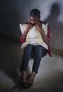 lifestyle indoors portrait of young sad and depressed black african American woman sitting at home floor feeling desperate and Royalty Free Stock Photo