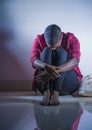 Lifestyle indoors portrait of young sad and depressed black afro American woman sitting at home floor feeling desperate and worrie Royalty Free Stock Photo