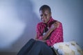 Lifestyle indoors portrait of young sad and depressed black african American woman sitting at home floor feeling desperate and wor Royalty Free Stock Photo