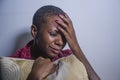 Lifestyle indoors portrait of young sad and depressed black afro American woman sitting at home floor feeling desperate and worrie