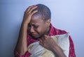 Lifestyle indoors portrait of young sad and depressed black afro American woman sitting at home floor feeling desperate and worrie